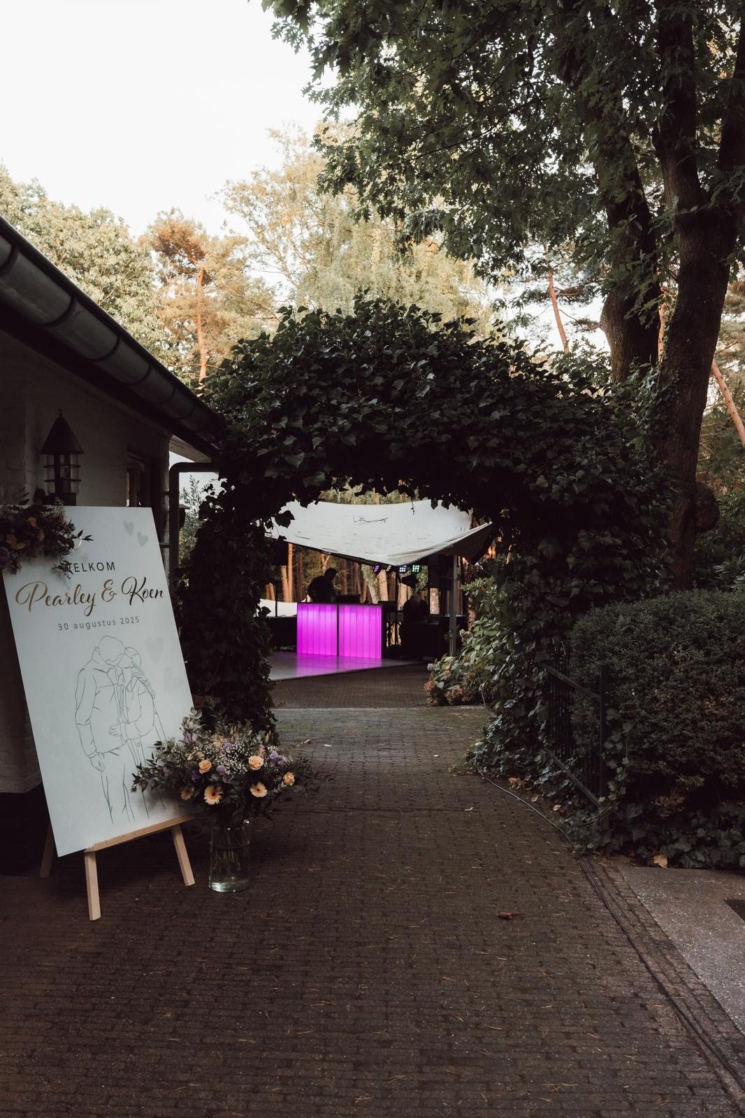 Welkomstbord bij de entree van een tuinbruiloft